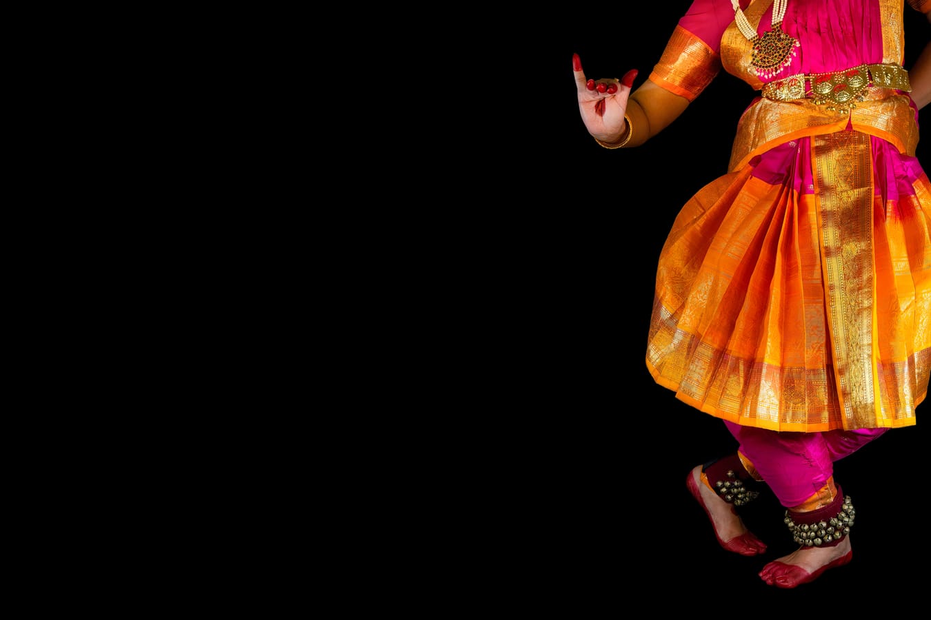 Bharatanatyam classical Indian dancer performing in dramatic stage lighting