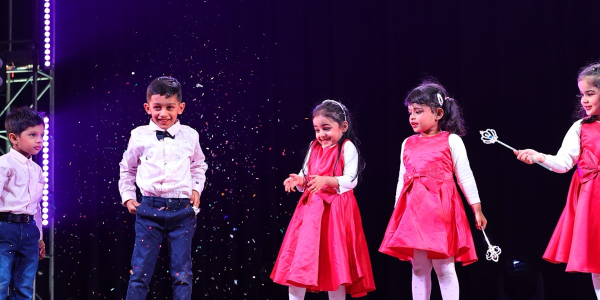 Kids celebrating with confetti on stage at Dancing Wonder